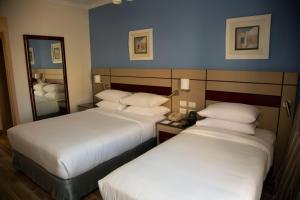 赫尔格达Swiss Inn Resort Hurghada的酒店客房,设有两张床和镜子