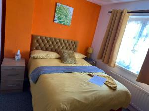克劳利Quick Stop Night Stay - Gatwick的一间卧室配有一张橙色墙壁的床