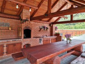 普拉伊德Dió vendégház的户外厨房配有木桌和 砖炉