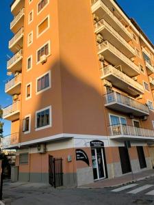 克罗托内皮塔戈拉住宿加早餐旅馆的一座高大的橙色公寓楼,设有窗户