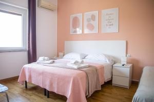 克罗托内皮塔戈拉住宿加早餐旅馆的一间卧室配有一张床,上面有两条毛巾