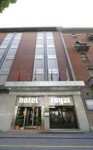 都灵Hotel Royal Torino Centro Congressi的建筑前方的商店,上面有旗帜