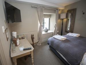 埃文河畔布拉德福蒂姆贝尔斯亚德宾馆的一间卧室配有一张床、一张桌子和一个窗户。