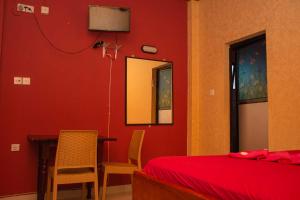 库鲁内格勒Hotel Janara的卧室设有红色的墙壁和桌椅