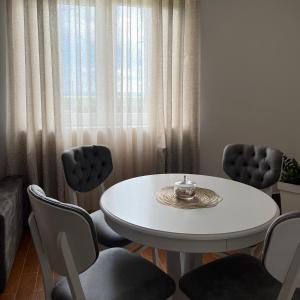 LedineSurčin Apartment的一间配备有白色桌椅的用餐室