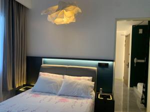 马六甲lmperio Residence Melaka - Private Indoor Hot Jacuzzi的一间卧室配有一张蓝色床头板的床