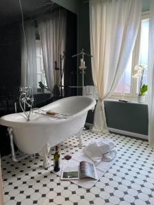 巴尼－迪卢卡Burlamacchi Villas的带浴缸的浴室和书本