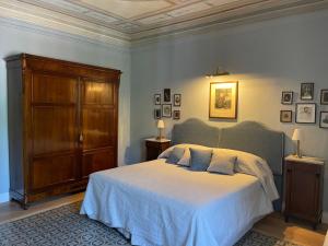 巴尼－迪卢卡Burlamacchi Villas的一间卧室配有一张大床和一个木制橱柜