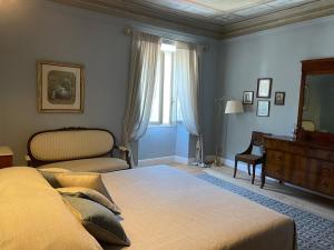 巴尼－迪卢卡Burlamacchi Villas的一间卧室配有一张床、一个梳妆台和一扇窗户。
