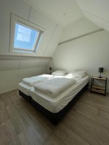 东卡佩勒Hèt Koetshuis的一间卧室设有一张大床和窗户