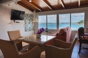 Five Islands VillageBeach Villa的客厅配有桌椅,享有海景