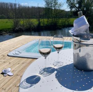 FourgesMoulin de Fourges的两杯酒坐在游泳池旁的桌子上