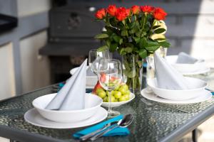 加茨比亚格拉Domki Apartamentowe - Na Makowej的一张桌子,上面有盘子和玻璃杯,花瓶
