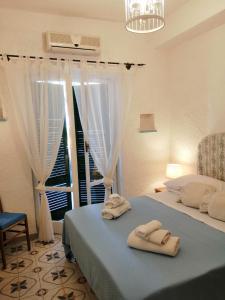伊斯基亚Santa Caterina的卧室配有带2条毛巾的窗户,位于床上