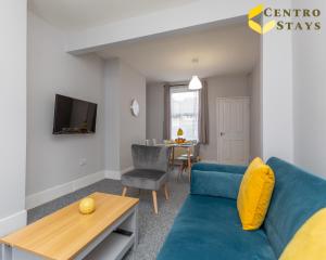 北安普敦Families Groups Contractors Relocation Free Parking & WiFi的客厅配有蓝色的沙发和桌子