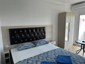 乌尔齐尼Apartments Flamida的一间卧室配有一张大床和黑色床头板