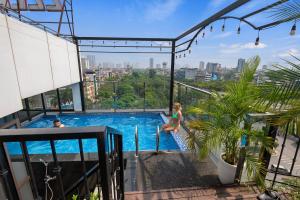 河内22Land Residence Hotel & Spa Ha Noi的建筑物游泳池里的男女