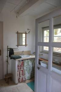 塞居勒La petite maison des artistes的白色的浴室设有水槽和窗户。