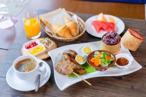 乌汶Tohsang Heritage Ubon Ratchathani Hotel的餐桌,早餐盘和咖啡