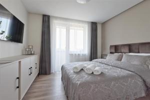 乌田纳Aušros apartamentai的一间卧室配有一张大床和两条毛巾