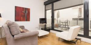 马德里My City Home - Hermoso apartamento en Calle Iriarte的客厅配有沙发和椅子