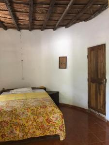 KafountineKaramba Lodge的一间卧室配有一张床和一扇木门