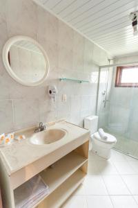 格拉玛多Tri Hotel Lago Gramado的一间带水槽、卫生间和镜子的浴室