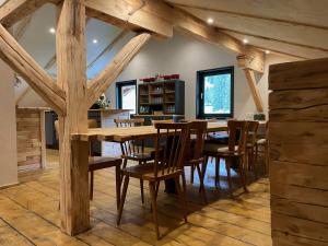 迈尔霍芬Backyard Mountain Hostel的一间带木桌和椅子的用餐室
