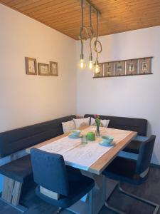 拉茨查赫·奥伯登弗Apartments Wrolich的餐桌和2把蓝色椅子