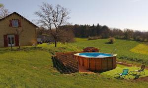 La Chapelle-AubareilLa Galinie的房屋旁的田野里的一个热水浴池