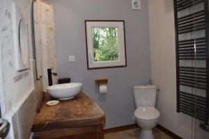 FrancueilLapis Domus的浴室设有卫生间和木台面上的盥洗盆。