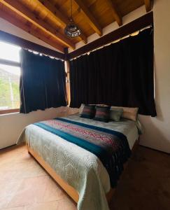 AmatlánCasa IxeYolo的一间卧室配有一张带黑色窗帘的床和一扇窗户