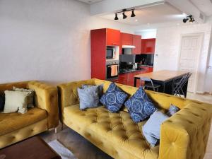 达布阿扎Magnifique Penthouse 140m2 de terrasse vue mer的客厅配有带蓝色枕头的黄色沙发
