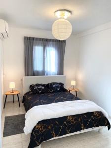 Qiryat H̱ayyimПрекрасная квартира на берегу Средиземного моря的一间卧室配有一张大床和两张桌子
