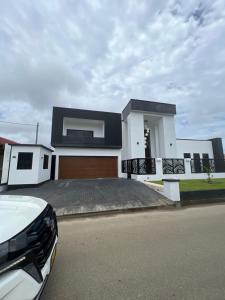 帕拉马里博Empire Villa Paramaribo Noord 1的黑色屋顶的白色房子