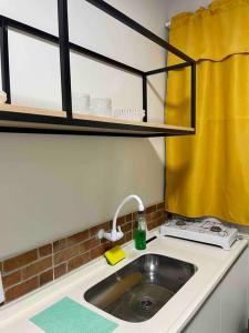 马卡帕Apartamento Studio Centro的厨房柜台设有水槽和黄色窗帘