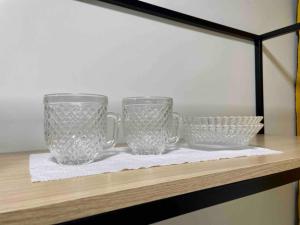 马卡帕Apartamento Studio Centro的架子上两个玻璃杯和碗