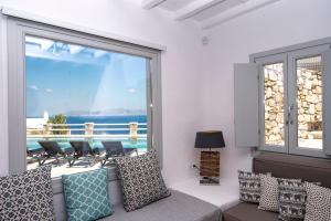 米克诺斯城Villa Orion Mykonos - Magnificent Sea View的带沙发和大窗户的客厅