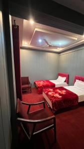 锡卡都Skardu Lodge的一间设有两张床和椅子的房间