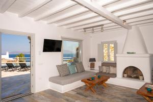 米克诺斯城Villa Orion Mykonos - Magnificent Sea View的客厅设有壁炉和电视。