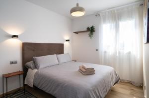 多列毛利诺斯Los Riscos Luxury Apartment - Torremolinos的一间卧室配有一张床,上面有两条毛巾