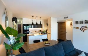 多列毛利诺斯Los Riscos Luxury Apartment - Torremolinos的客厅以及带蓝色沙发和桌子的厨房。