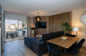 多列毛利诺斯Los Riscos Luxury Apartment - Torremolinos的客厅配有蓝色的沙发和桌子