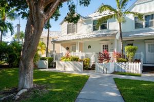 鸭礁岛Beach House Getaway的白色的房子,有围栏和棕榈树