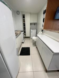 若昂佩索阿Loft Luxor Tambaú的一间小厨房,配有白色橱柜和黑色地毯