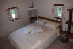 FrancueilLapis Domus的卧室配有白色床和2扇窗户