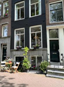 阿姆斯特丹Singel Residence的前面设有桌椅的黑色房子