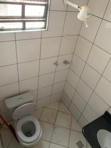 马拉巴PREMIER HOTEL的白色的浴室设有卫生间和窗户。