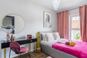 罗兹Lumina premium apartments with balcony, parking的一间卧室配有一张床和一张带粉红色毯子的书桌
