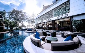 芭东海滩Phuket Graceland Resort and Spa的一个带游泳池和椅子的度假胜地和一座建筑
